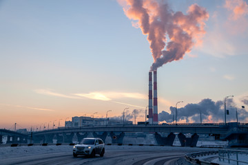Cityscape car rides on background of bridge, smoke of factory pipes pollutes atmosphere. Concept of...