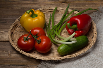 On a wicker dish are fresh, appetizing vegetables.