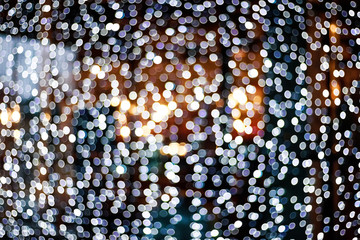 Blurry facade with garlands. Christmas lights in the windows. Bokeh background