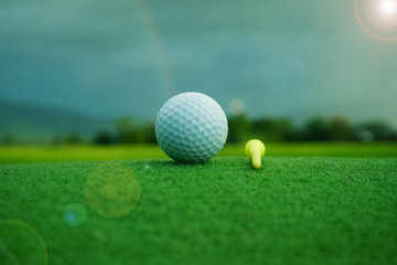 Golf ball on green in beautiful golf course at sunset background.
