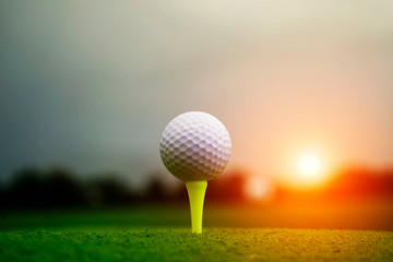 Golf ball on tee in beautiful golf course at sunset background. Golf ball on green in golf course at Thailand
