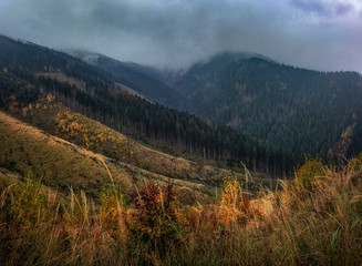 Mountain landscape in autumn.Mountain forest landscape under evening sky with clouds in sunlight.Natural outdoor travel background.Autumn mountain landscape in Slovakia.