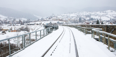 railway in snow on the railway bridge in the mountains