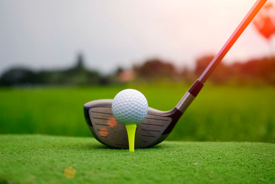 Blurred golf ball and golf club in beautiful golf course at sunset background.