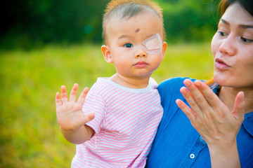 Asian female model and asian baby pose for pictures in the nature