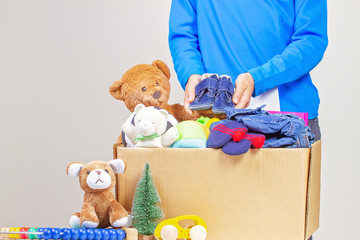Kid hold Christmas donation box with toys, books, clothing for charity