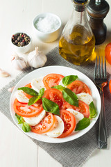 Close-up photo of caprese salad with ripe tomatoes, basil, buffalo mozzarella cheese. Italian and Mediterranean food concept. Fresh and healthy organic meal. Starter and antipasti. 