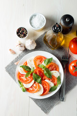 Close-up photo of caprese salad with ripe tomatoes, basil, buffalo mozzarella cheese. Italian and Mediterranean food concept. Fresh and healthy organic meal. Starter and antipasti. 