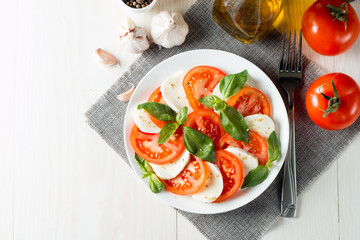 Close-up photo of caprese salad with ripe tomatoes, basil, buffalo mozzarella cheese. Italian and Mediterranean food concept. Fresh and healthy organic meal. Starter and antipasti. 