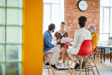 Several colleagues sitting in circle during business discussion or consultation about features of...
