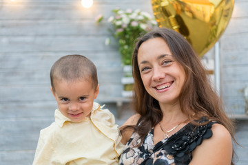 Mom holds a child in her arms. A happy family. Young mother holding her baby in her arms and stroked my mother's child litso.Portret mother and little son