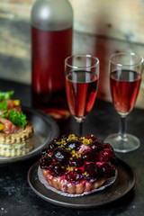 sweet meal for two: red wine, cake with icing and fruit, French patties