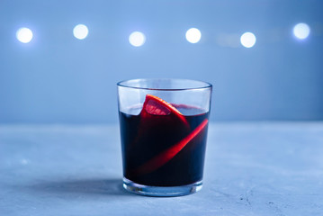 Glass of red beverage with citrus slices