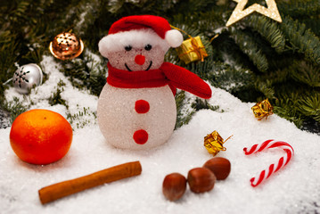 A snowman with a hut and a scarf and some winter and christmas decoration
