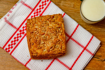 Healthy homemade pastry with integral flour and sunflower seeds and with yogurt. Wooden table and rustic vintage background. Close-up.