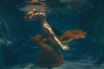 cute sporty girl swims underwater as a free diver in lingerie and mesh catsuit with rhinestones...