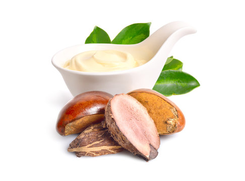 Shea nuts with butter or cream in the bowl. Isolated on white ba