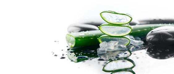 Aloe Vera sliced leaf and spa stones closeup on white background, natural organic renewal cosmetics, alternative medicine. Skincare concept