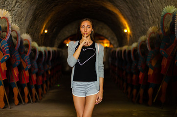 young woman in a long tunnel with statue