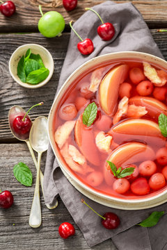 Yummy fruit soup with cherries, apples and mint
