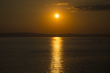Sunset above sea wtih clouds and red heaven