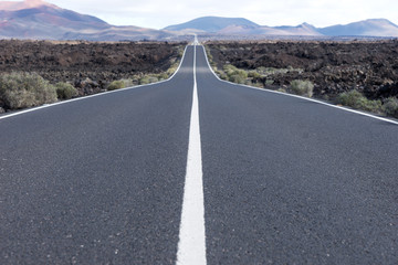 Endless highway through the volcanic landscape. Lanzarote. Canary islands. Spain