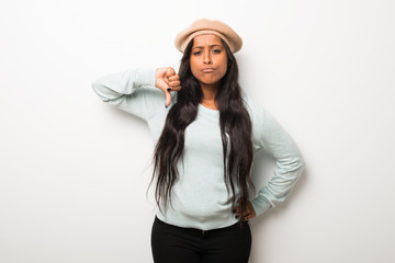 Young afro american woman on white wall showing thumb down sign with negative expression