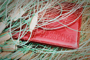 Red passport closeup caught in a fishing net. The concept of the fight against poachers and illegal...
