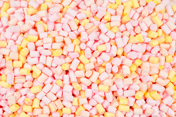 Fototapeta na wymiar Marshmallow. Background of pink and yellow colorful mini marshmallows.