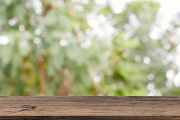 Empty wooden table template top on nature green blurred background for montage of your product on table.