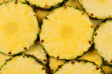 Pineapple juicy yellow slices background. Top view.