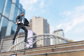 A businessman levitate from the ground with the buildings on the background