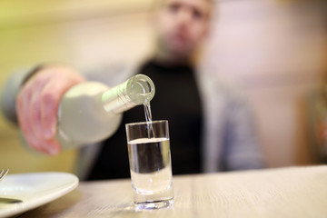 Man pouring vodka into glass
