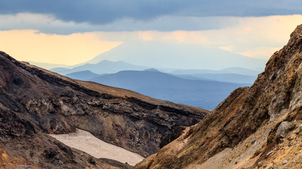 Rays of the sun make their way through the clouds. Sunset on the Mutnovsky volcano, Kamchatka Peninsula, Russia