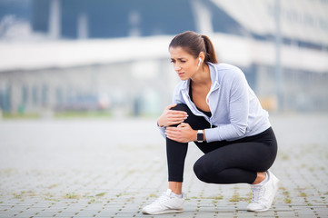 Fitness. Athletic women holding knee having a trauma