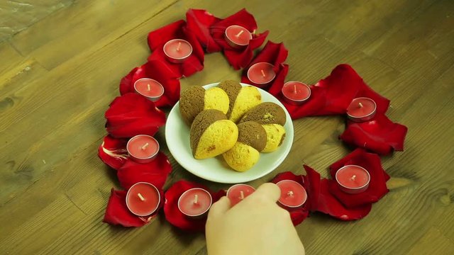 The girl puts a plate of cookies in the middle of the heart