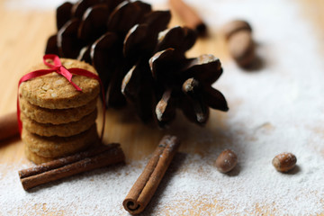Christmas or New Year background of spices, nuts, cones. Biscuits with red ribbons