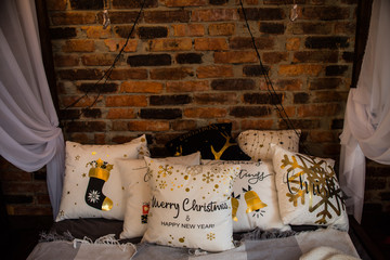 many different decorative pillows on bed baldachin brick wall © Yulia
