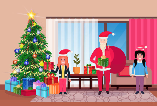 merry christmas happy new year snata claus with children in living room pine tree home interior decoration winter holiday concept flat horizontal