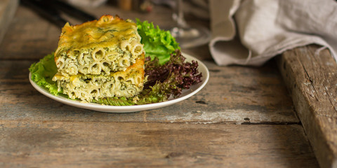 pasta casserole - penne, cheese, spinach, broccoli - main dish  (dark background). top view. copy space