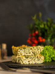 pasta casserole - penne, cheese, spinach, broccoli - main dish  (dark background). top view. copy space