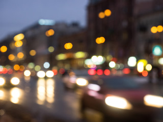 the city hallowed night street in the blurred focus on which cars go and multi-colored glare of headlights and lanterns are visible