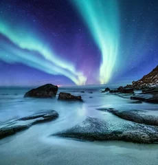 Foto auf Glas Aurora borealis auf den Lofoten, Norwegen. Grüne Nordlichter über dem Ozeanufer. Nachthimmel mit Polarlichtern. Natürlicher Hintergrund in Norwegen © biletskiyevgeniy.com