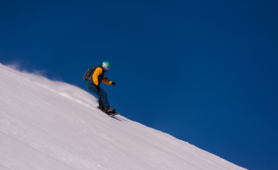 Fototapeta na wymiar snowboarder running down the slope and ride free style