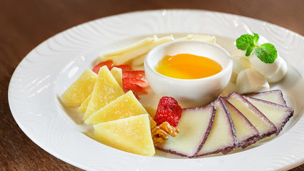 Cheese slices, honey in a plate, dinner