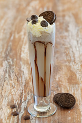 Milkshake in a glass on a wooden background