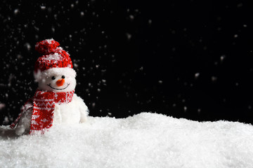 Decorative snowman on black background, space for text. Winter weather