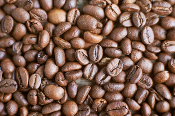 Roasted coffee beans on rustic wooden background. Food ingredients, top view, space for text