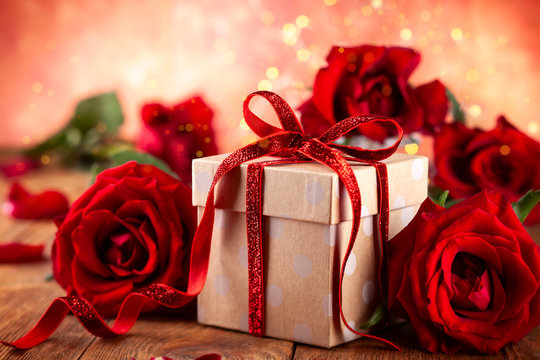 Gift box with red ribbon bow and red roses