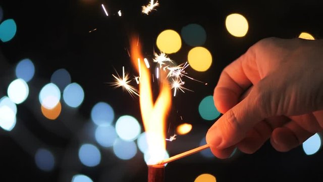 Fire up firework candle in slow motion, New Year and Christmas holiday background